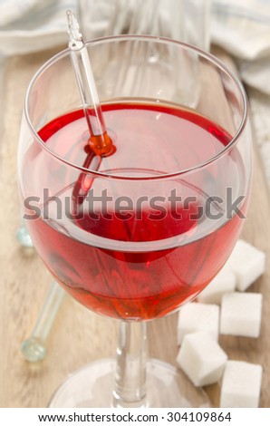 Red wine toddy in a glass with sugar cubes and glass pestle