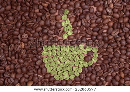 Cup made of green coffee beans on the background of coffee beans
