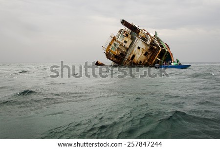 Shipwreck, rusty ship wreck, tourists near the sunken ship