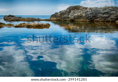landscape, seascape, coastal cliffs in the Bay, clouds reflected in water