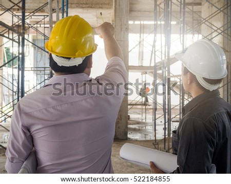 Engineer discussing with foreman about project in building construction site