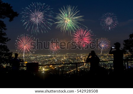 People looking at fireworks in the sky over the city