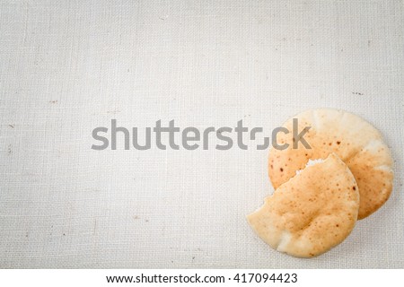 Pita or Arabic bread, soft baked flatbread on canvas background with free space for text