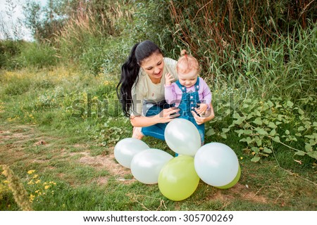 Beauty Mum and her Child playing in Park together. Outdoor Portrait of happy family