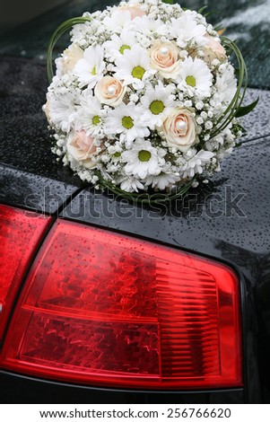 Bouquet of daisies and roses on a car