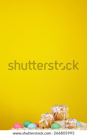 Yellow background colorful Panettone Kulich cakes with easter eggs. Depth of field