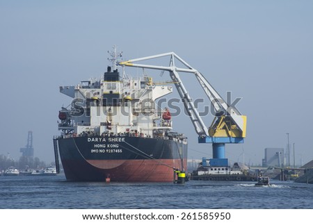 Port of Amsterdam, Noord-Holland/Netherlands - March 09-03-15 - Motor vessel Darya Shree is moored at the bollards. Floating crane Cornelis Tromp is in between and is loading the vessel with granite.