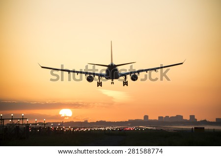 Airplane is landing during sunrise.