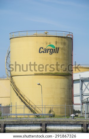 Port of Amsterdam, Noord-Holland/Netherlands - June 25-06-2015 - Yellow tank from the company Cargill placed next to the shore. Blue sky at the background.