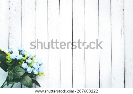 Vintage Tone Soft Focus of Blue Fake Flowers on White Wooden Wall Plank - Texture Background