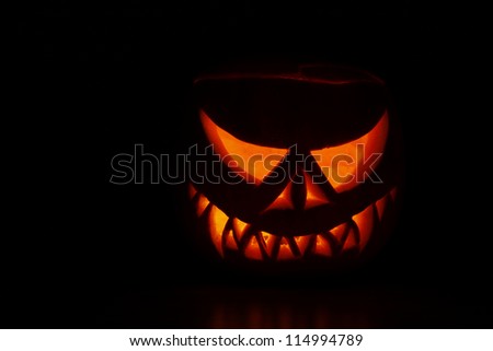 Pumpkin carved into spooky demon face for haloween