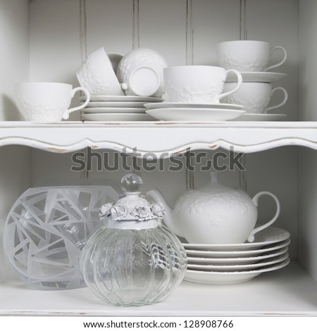 pure white cup  with plate , standing in white cupboard