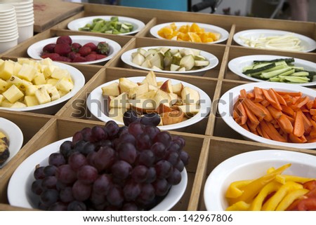 fruits and vegetables slices in green red and yellow colors on the plates in the box on display
