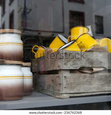 yellow porcelain cups of 1950-th years in the wooden box in the window of shop. The simple form, glazed texture, small flower image.Good for background. London flea-market