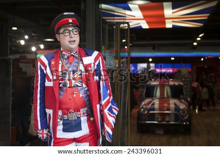 LONDON - OCTOBER 18TH: Seller wears uniform symbolizing English flag at entrance of shop Cool Britannia. In background car painted in color of British flag. October 18th, 2014 in London, England, UK.
