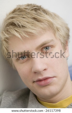 closeup portrait of young blond smiling man with blue eyes.