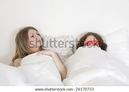 Strange couple lying in bed. Person wearing red funny glasses