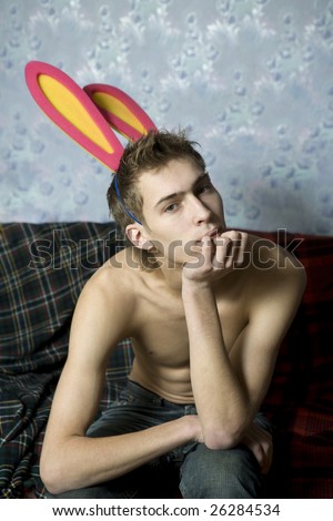 portrait of young cute thoughtful man with pirsing in eyebrow and rabbit`s ears