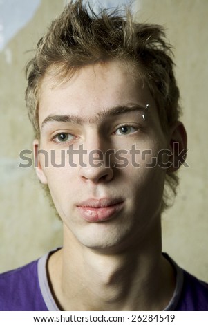 portrait of young cute thoughtful man with pirsing in eyebrow