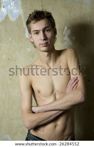 portrait of young man with pirsing in eyebrow standing at the wall