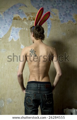 stock photo man with tattoo on the back and rabbit s ears standing at