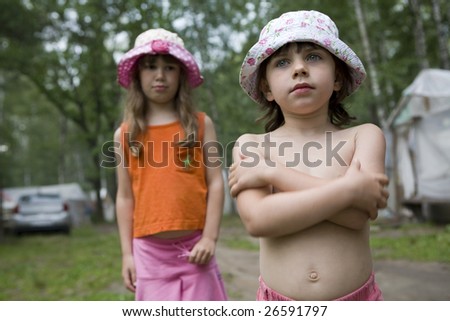 two little girls wearing panama standing in camp. Friendship. Summer time