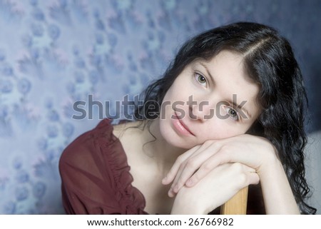 portrait of young serious woman  in front of wallpaper