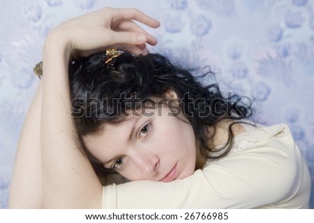 portrait of young serious woman  in front of wallpaper. Woman`s problem
