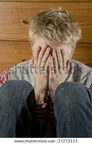 young hopeless blond man close eyes by hand