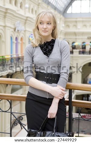 young attractive blond woman standing at railing in state department store. Moscow. Shopping