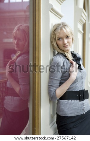 young attractive blond woman standing at wall in state department store. Moscow. Shopping