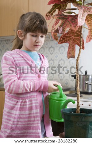 little cute girl seven years old with watering-can pour on plant on kitchen