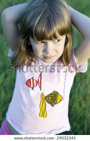 Little cute pensive  girl six years old standing in the middle of the meadow