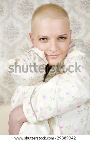 portrait of young attractive smiling bald woman in pyjamas