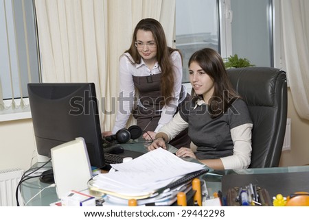 Two colleagues discuss some problem using computer. Office people