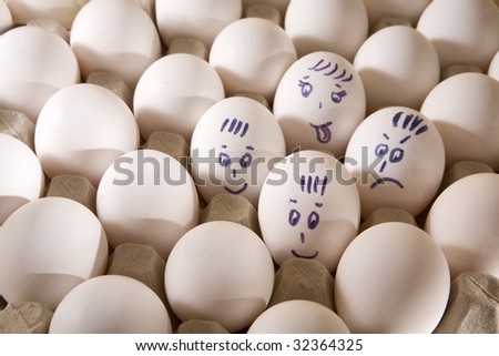 Hen`s eggs in box. Four eggs cover with drawings. Look like man`s face