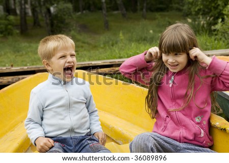boy five years old shouting and girl cloher ears