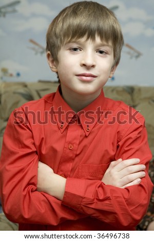 portrait little boy in red shirt opposite wallpaper in airplane