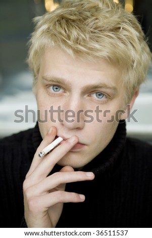 young blond man smoking in street