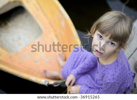 little cute pensive girl sitting at yellow boat