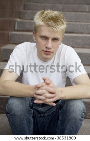 upset young man sitting on stairs put his head on knees