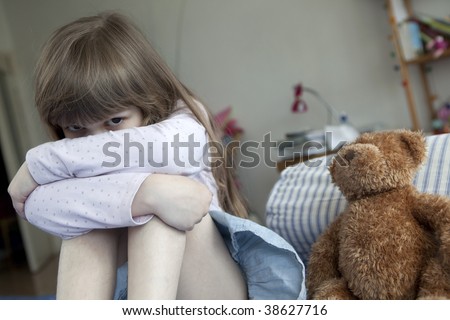 little cute girl seven years old  sitting on bed and crying