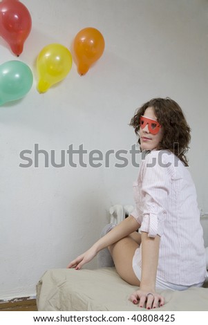 strange young curl woman in red paper glasses sitting on sofa after party