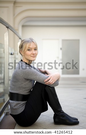sad woman sitting on floor at big store resting after shopping