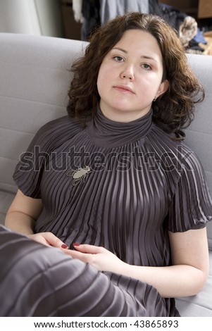 portrait of young calm woman sitting on couch