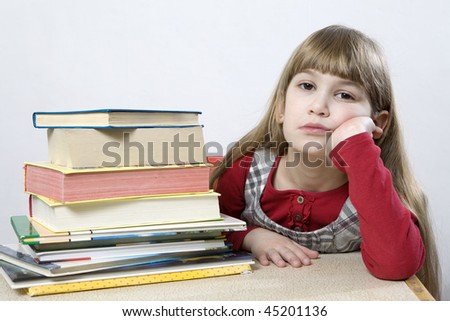 Is it possible to read all these books? little cute sad  girl with a pile of book sitting at table.