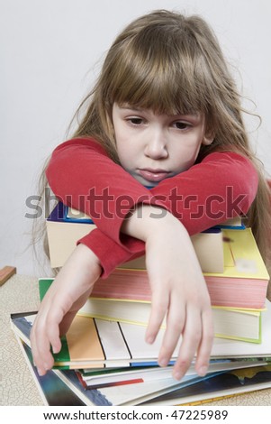 Is it possible to read all these books? little cute sad girl with a pile of book sitting at table.