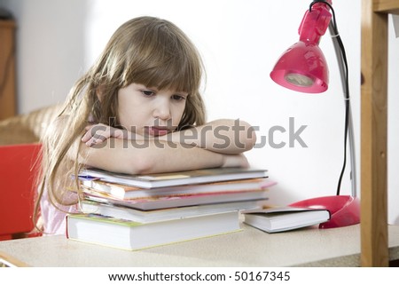 Is it possible to read all these books? little cute sad girl with a pile of book sitting at table.