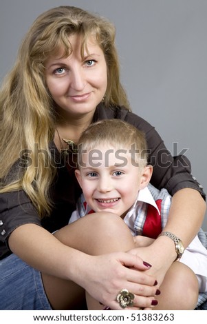 happy mother hugs her blond smiling son