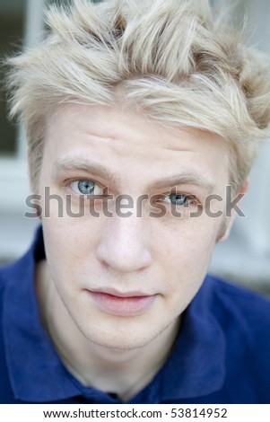 portrait serious blond man with short hair wearing blue t-shirt